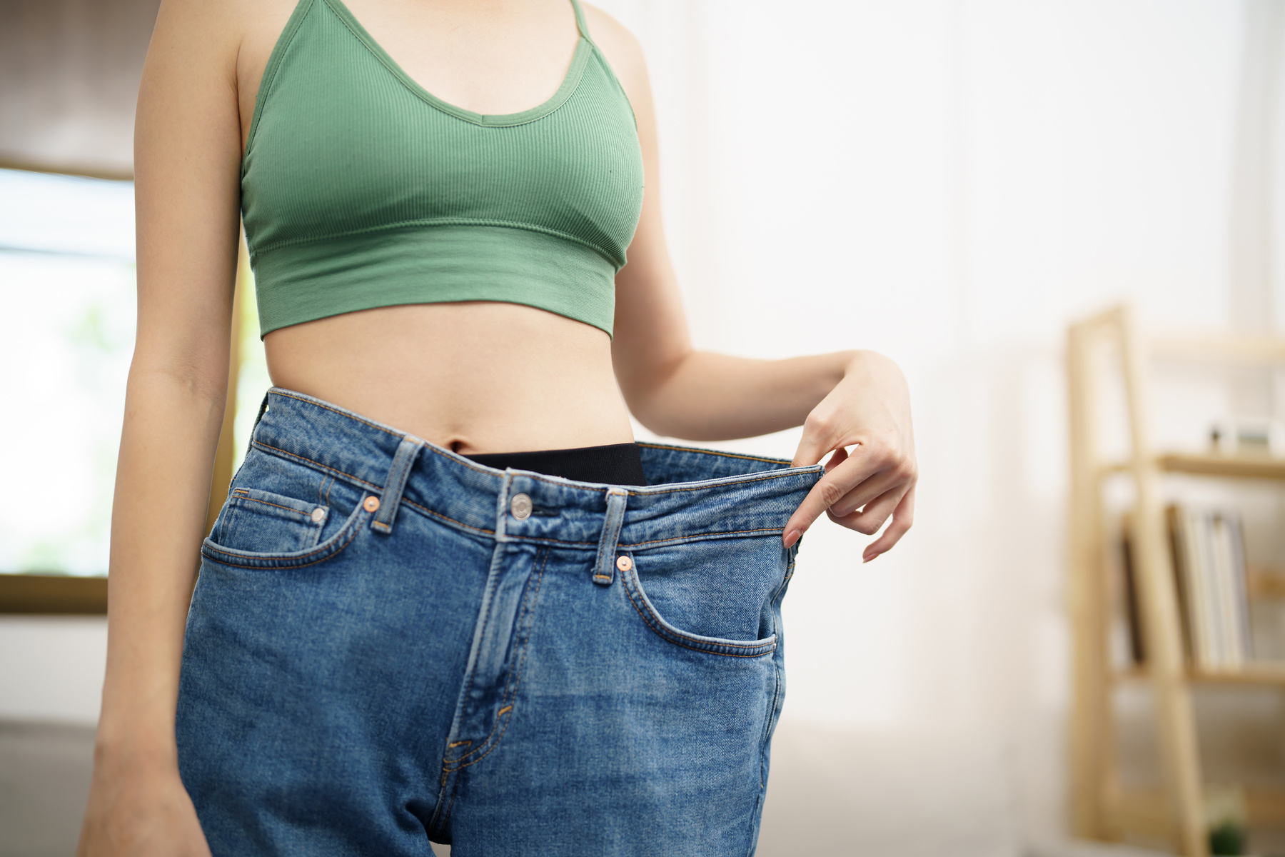 Asian woman dieting Weight loss. Slim woman in oversize jeans